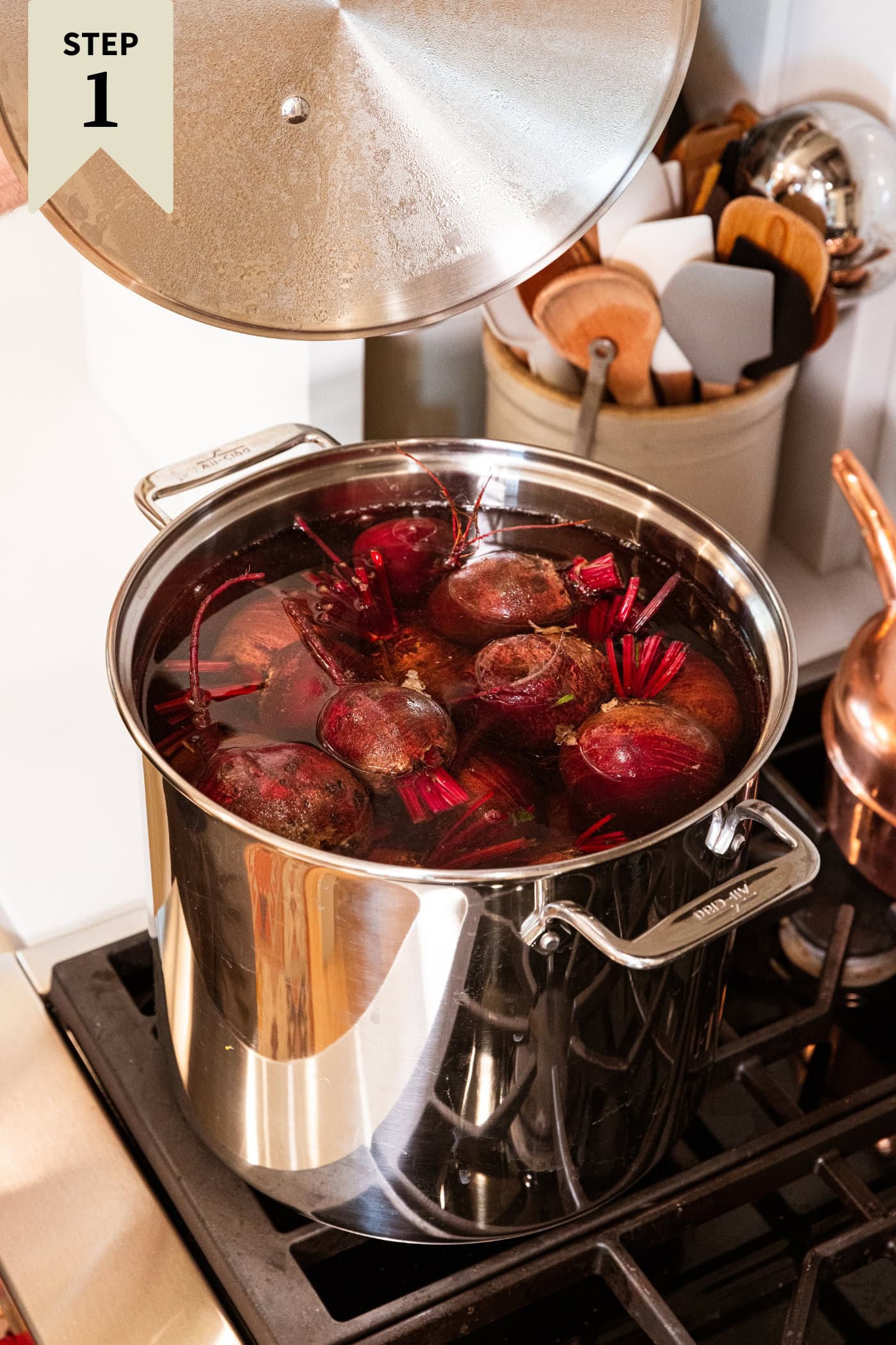 Large metal stockpot on the stove with red beets cooking with lots of water.