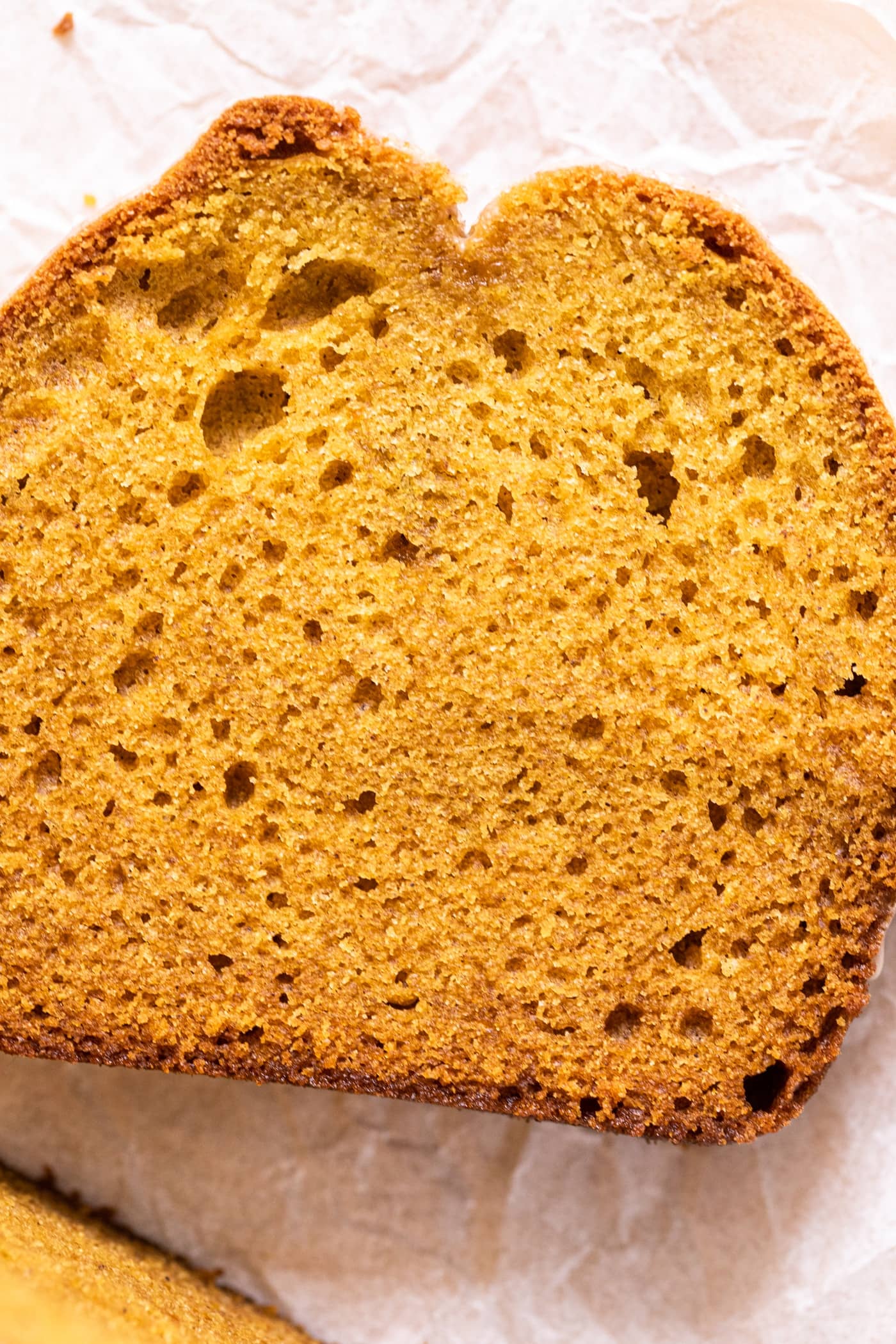 Top down close up view of slice of pumpkin loaf showing air pockets in the bread