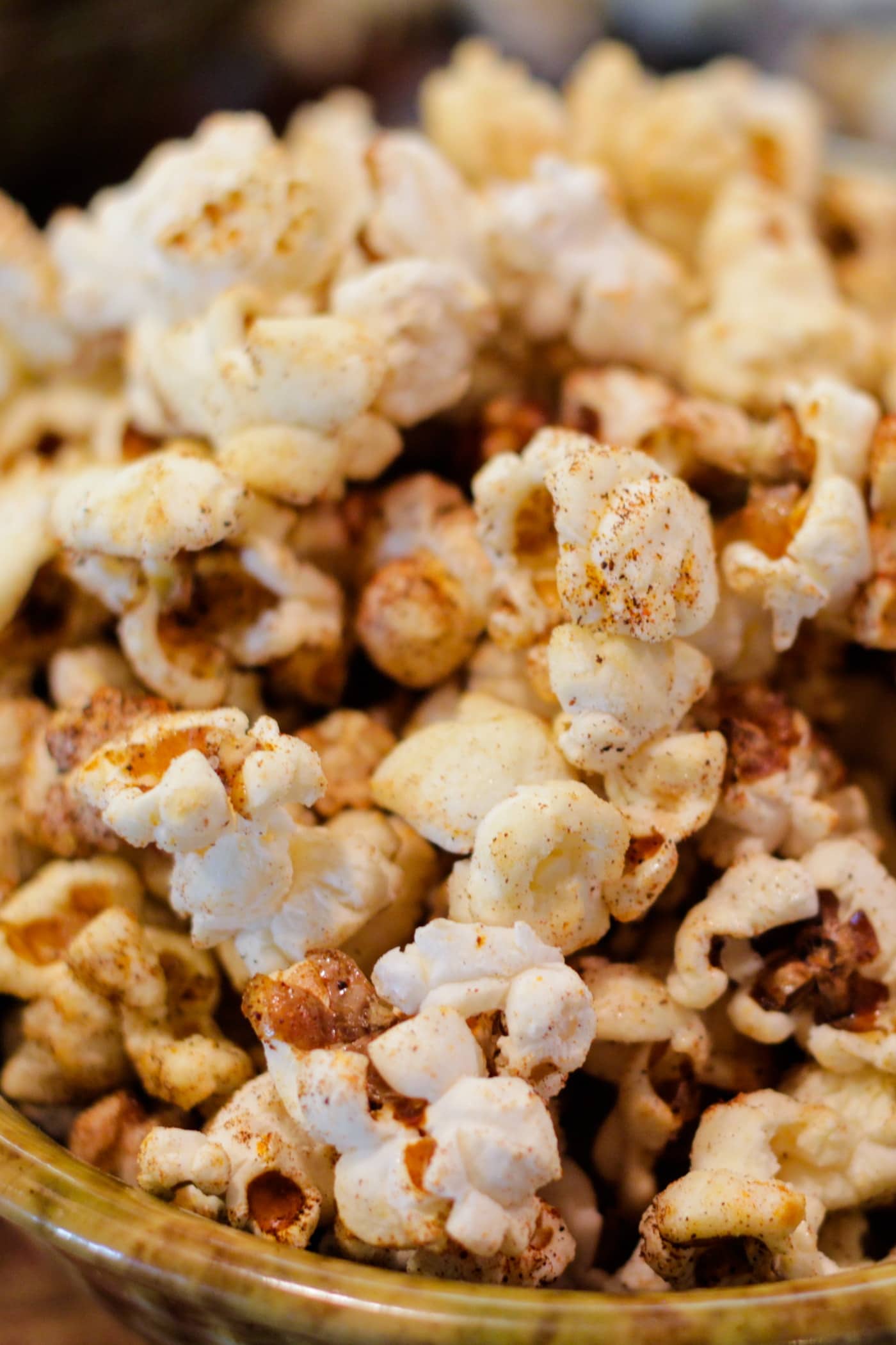 Bowl full of kettle corn sitting on wood surface with extra bowl in background