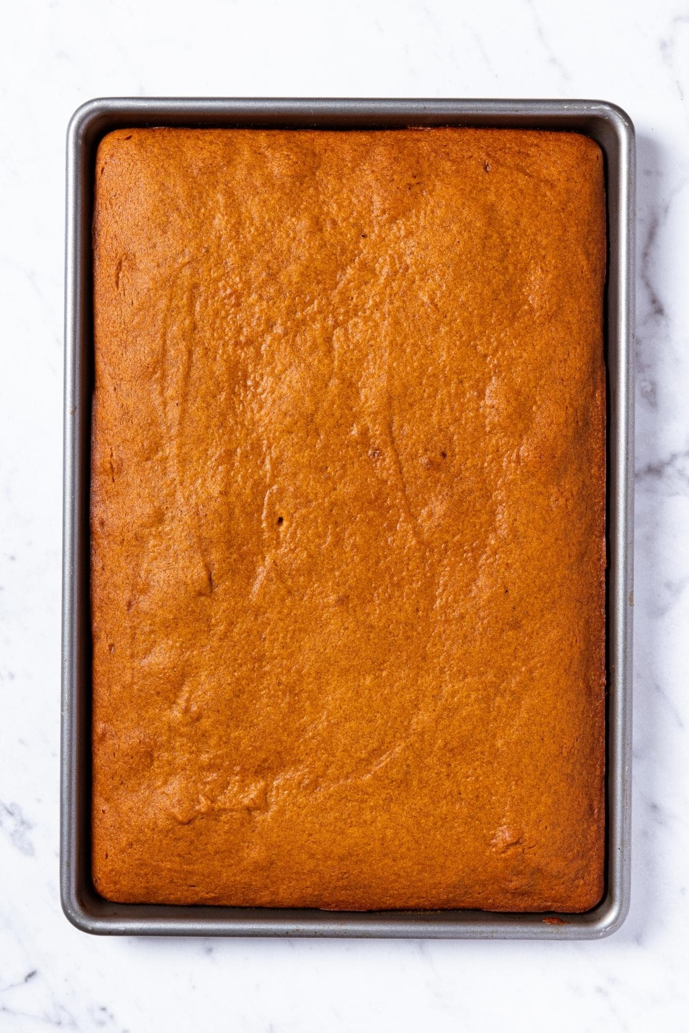 Large sheet pan with baked pumpkin bars right after coming out of the oven.