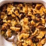 Top down view of toasty golden slow cooker stuffing sitting in white baking dish sitting on wood countertop