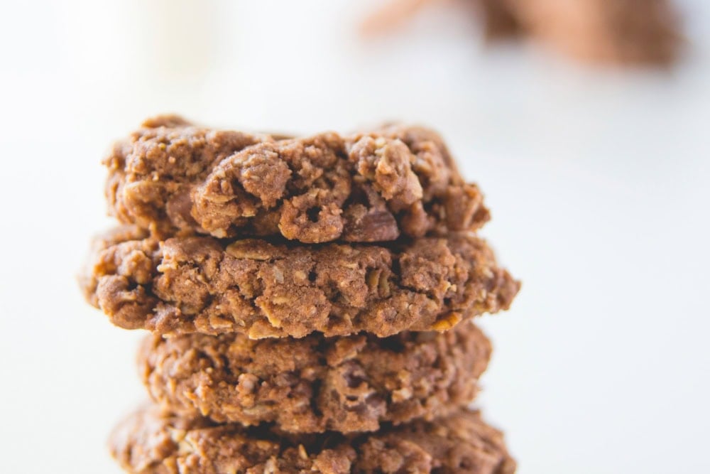 Double chocolate oatmeal cookies stacked on top of each other showing craggy texture.