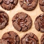 Piece of parchment with chocolate mint cookies with mint spread on top.
