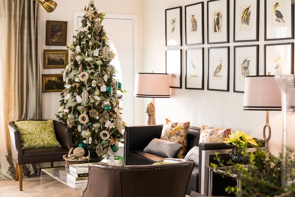 Living room filled with Christmas decor including Christmas tree with lots of silver colored ornaments.