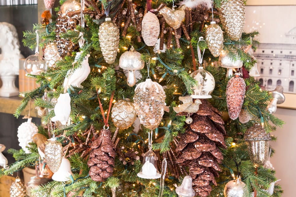 Glass and woodland-themed mushroom ornaments hung on a green Christmas tree.