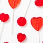 Top down view of red suckers shaped in circles and hearts all on white countertop