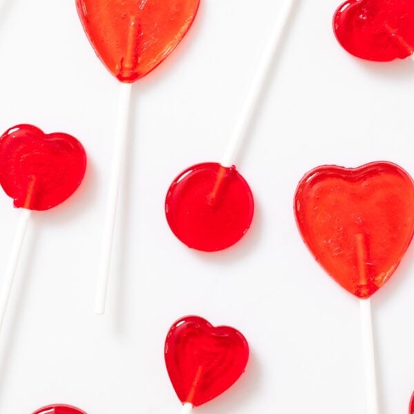 Top down view of red suckers shaped in circles and hearts all on white countertop