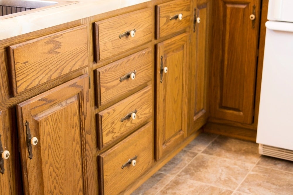 Cherry brown lower cabinets with pulls and knobs