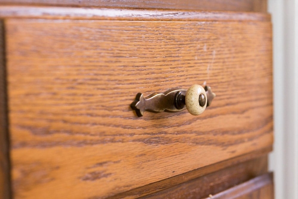 Close up view of cherry brown cabinets with 1980's pull handle