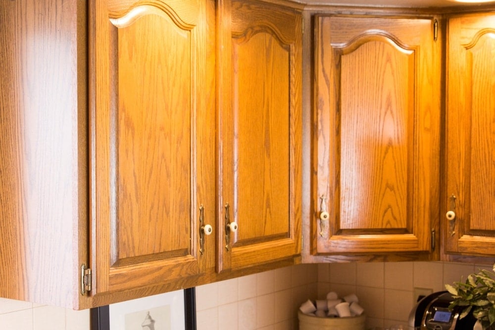 Cherry brown kitchen upper kitchen cabinets with items on countertop below