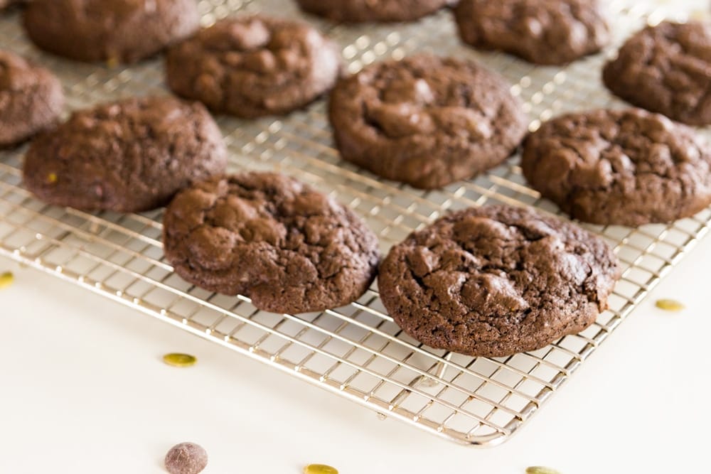 Spicy dark chocolate cookies sitting on wire cooling rack on white countertop