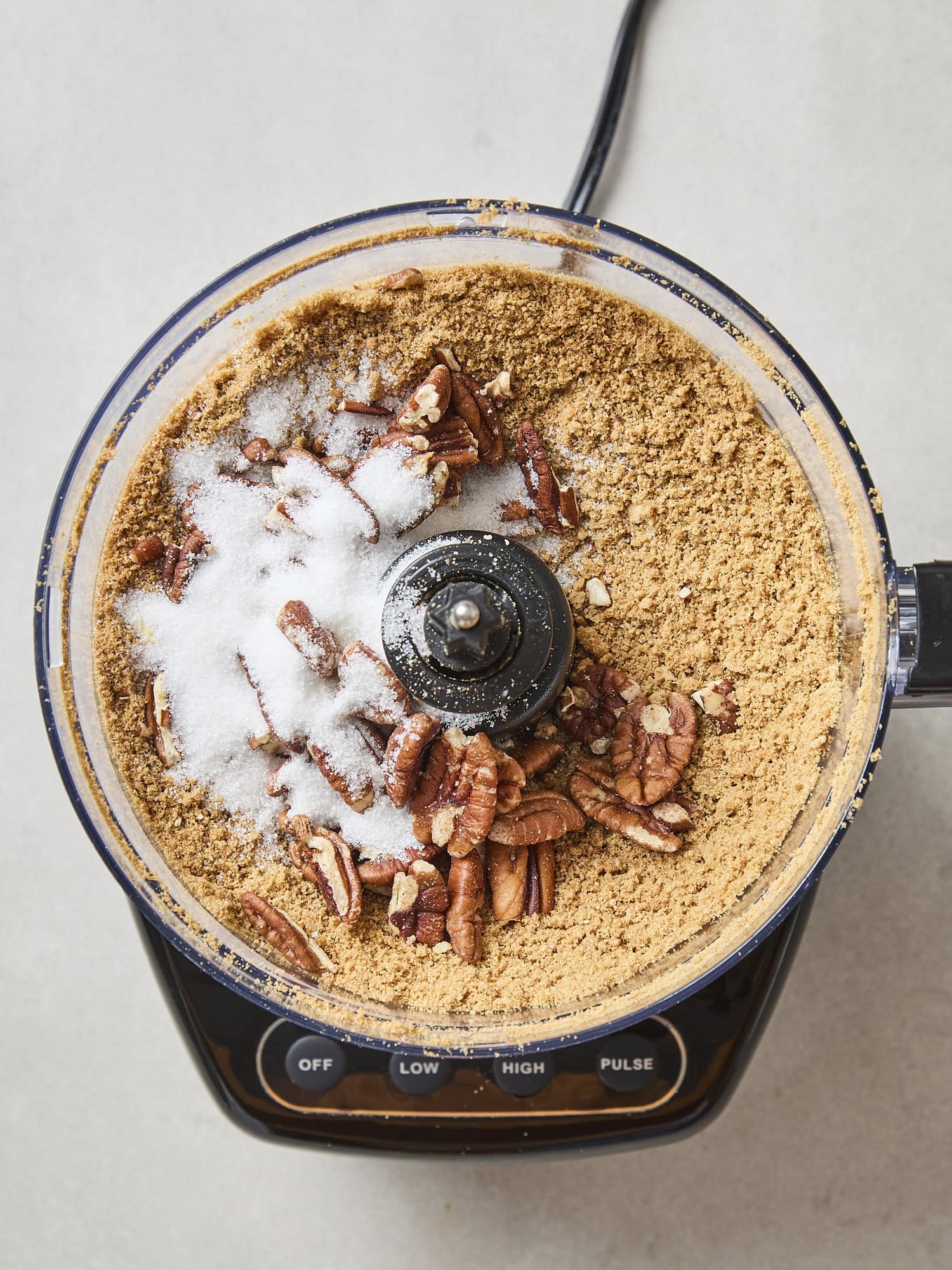 Gingersnap cookie crumbs with sugar and pecans in a food processor for a crust.
