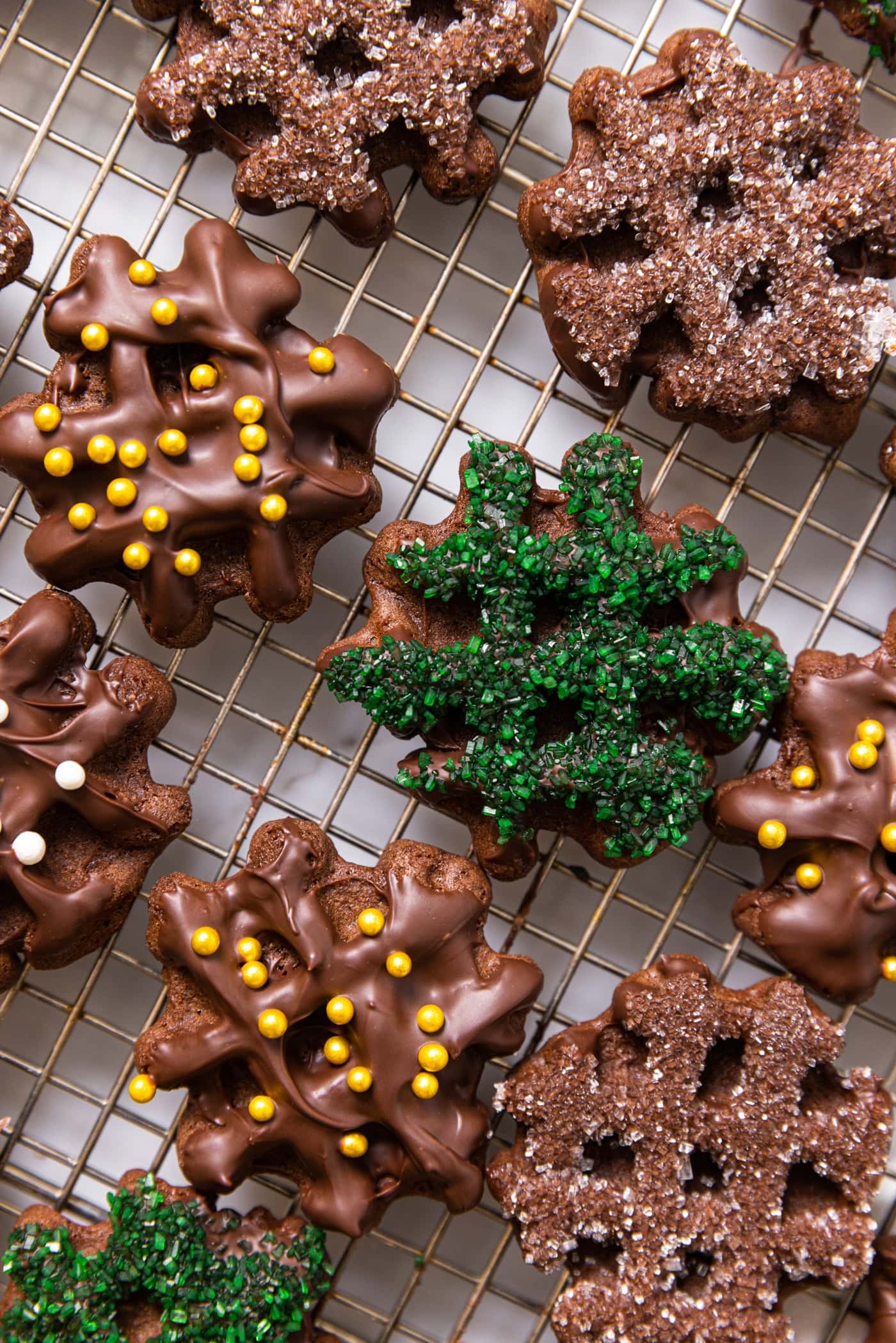 Top down view of chocolate waffle cookies with colored sugar on top along with differently colored dragees