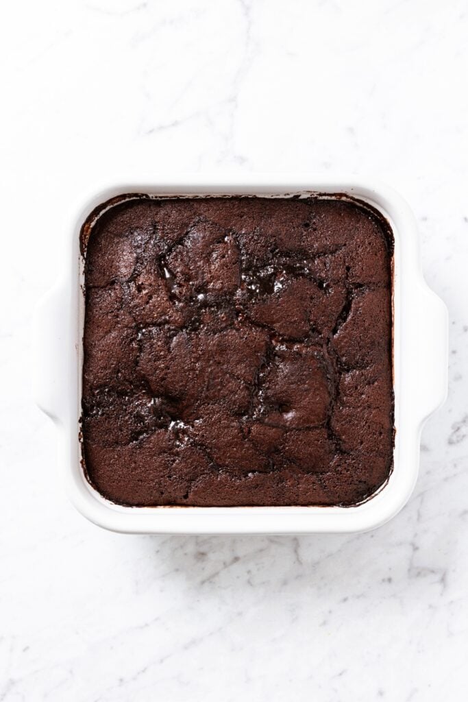 White marble surface with baked chocolate pudding cake right after coming out of the oven.