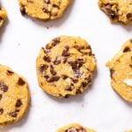 Top down view of baked chocolate chip and oatmeal refrigerator cookies sitting on white piece of parchment