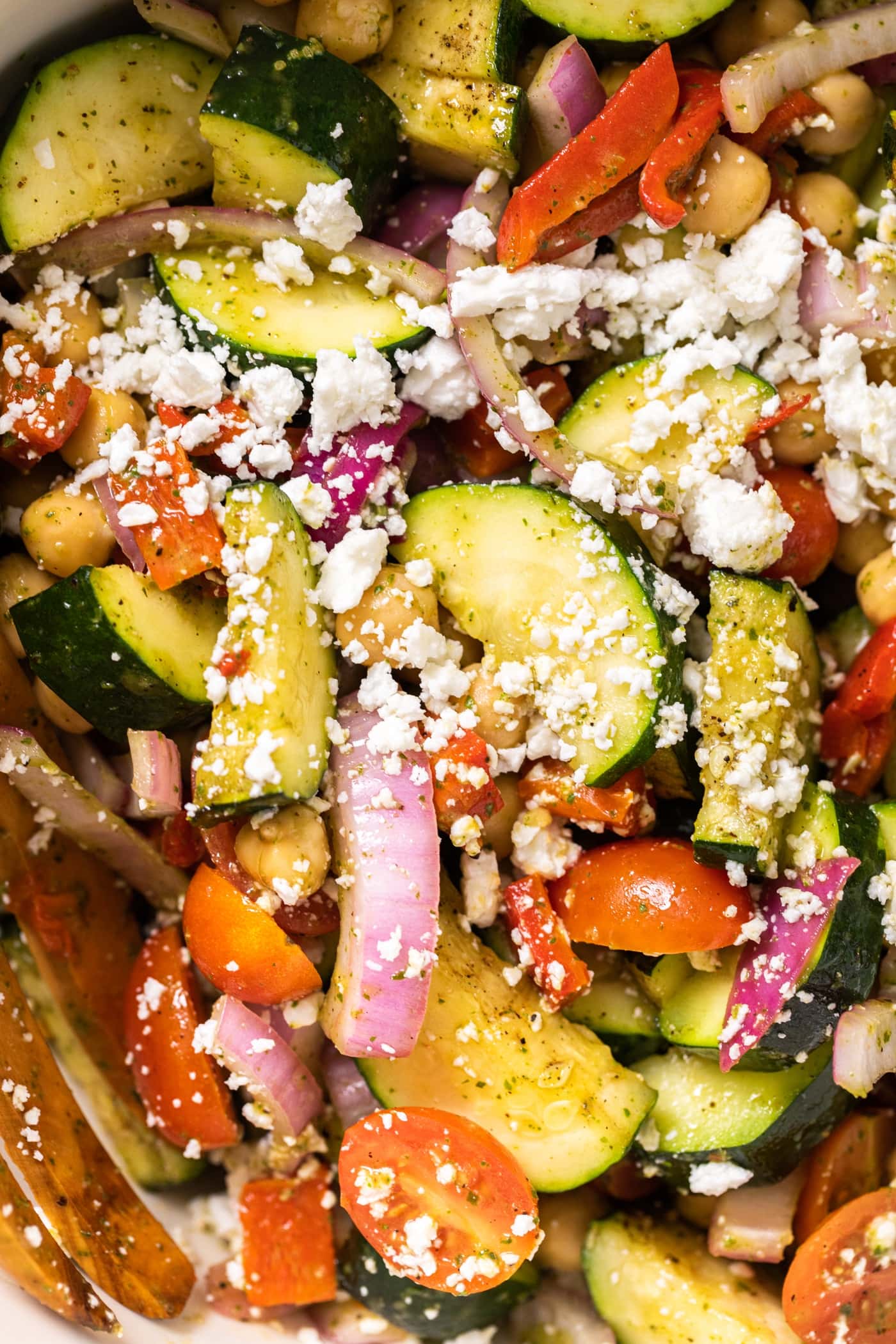 Close up top down view grilled zucchini and onion with tomatoes and feta all sitting together