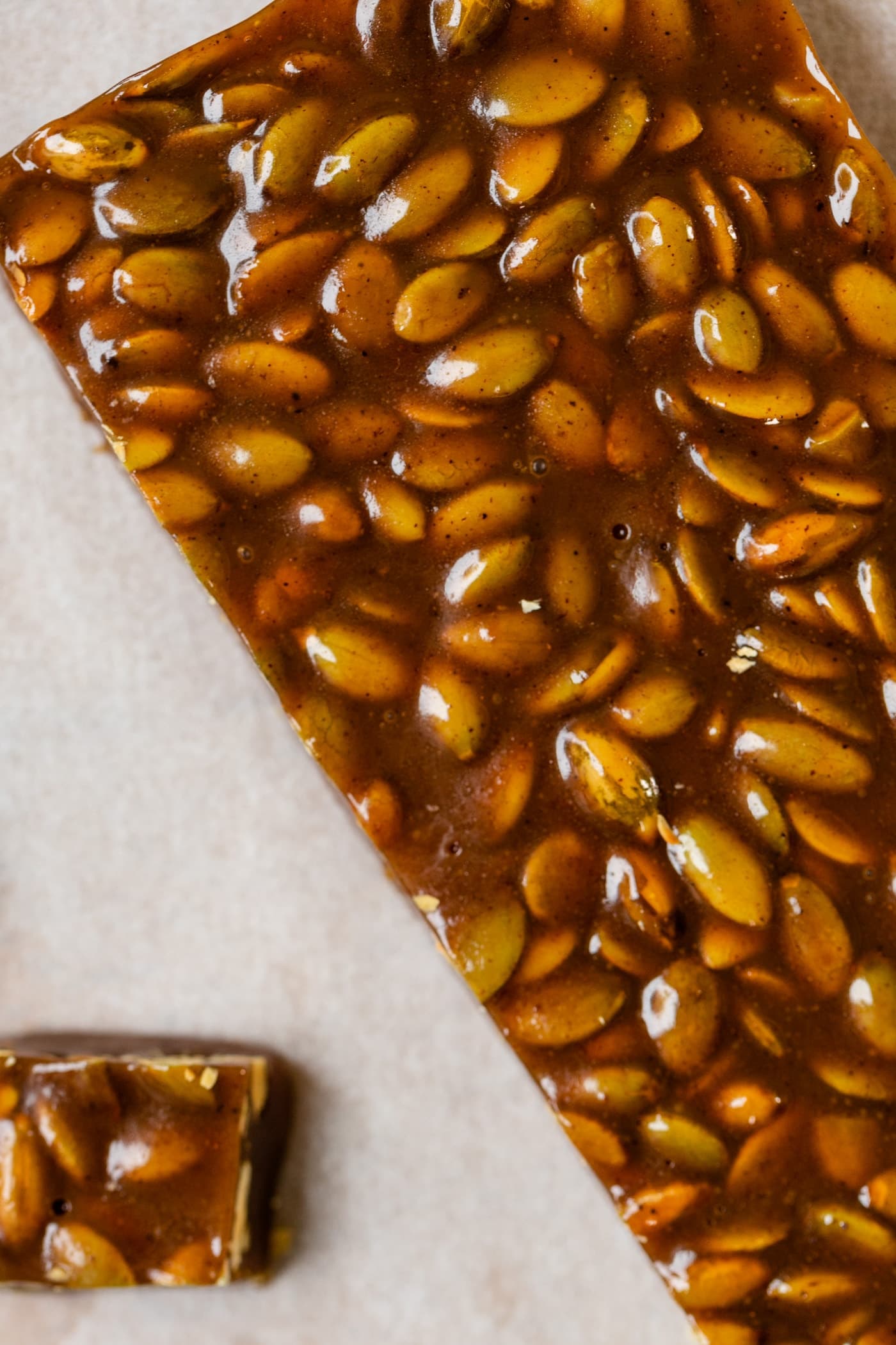 Top down view of bar to be cut into pumpkin spice caramels sitting on piece of white parchment paper
