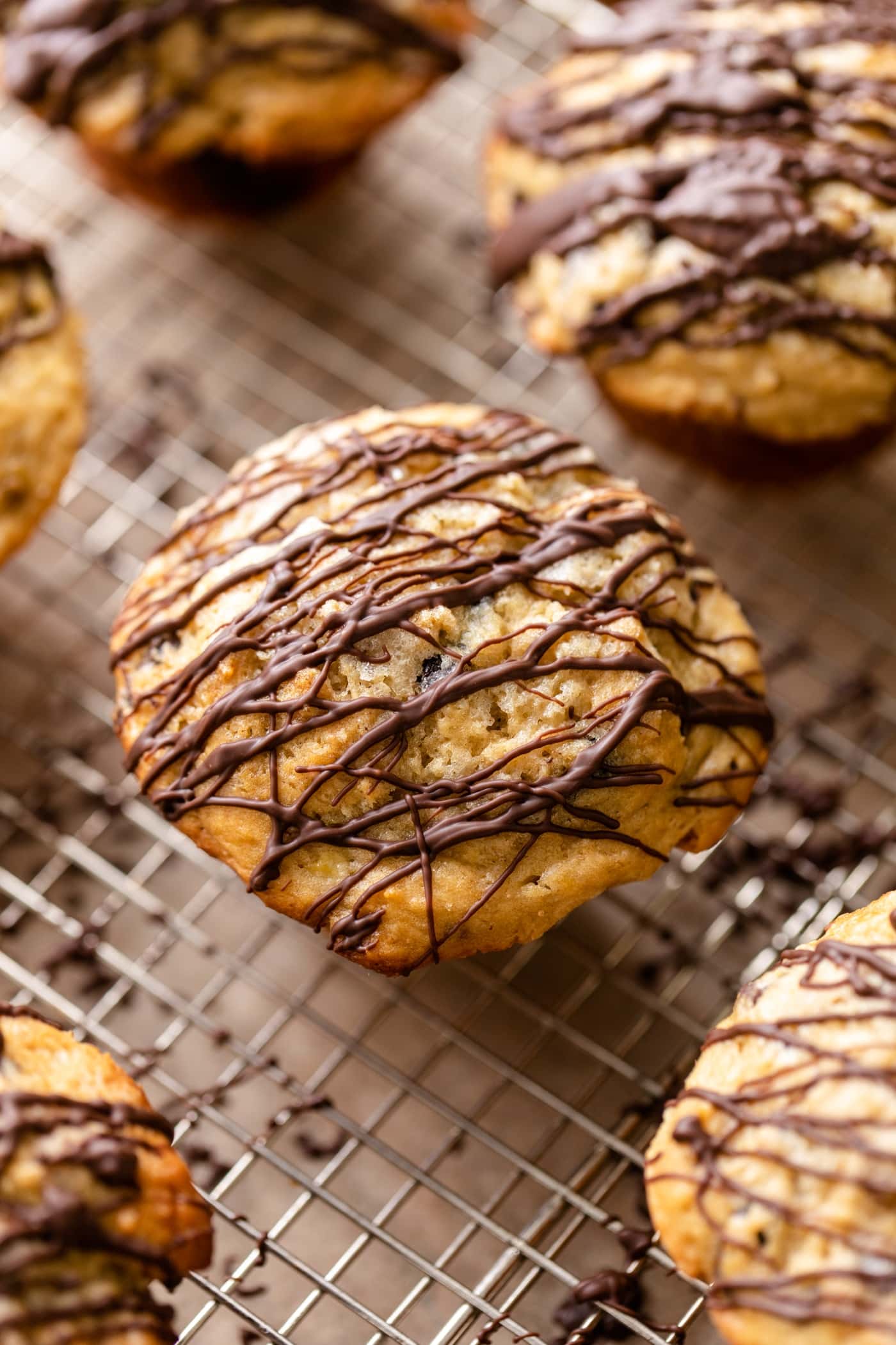 Top down view of banana muffins drizzled with chocolate sitting on wire cooling rack