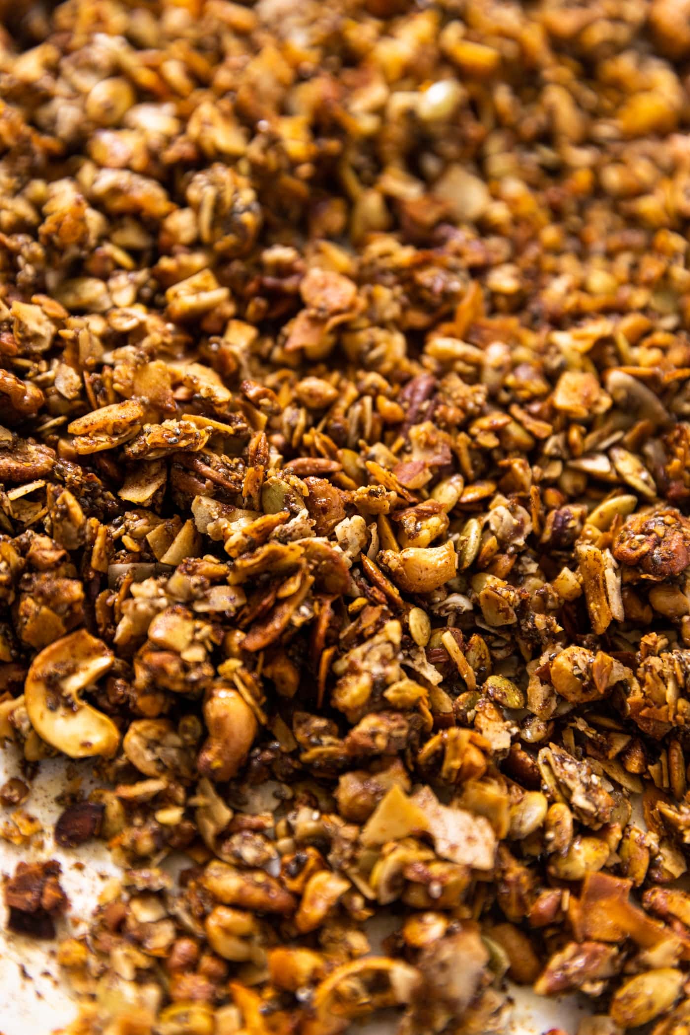 Pile of grain-free granola sitting on parchment paper in metal baking pan
