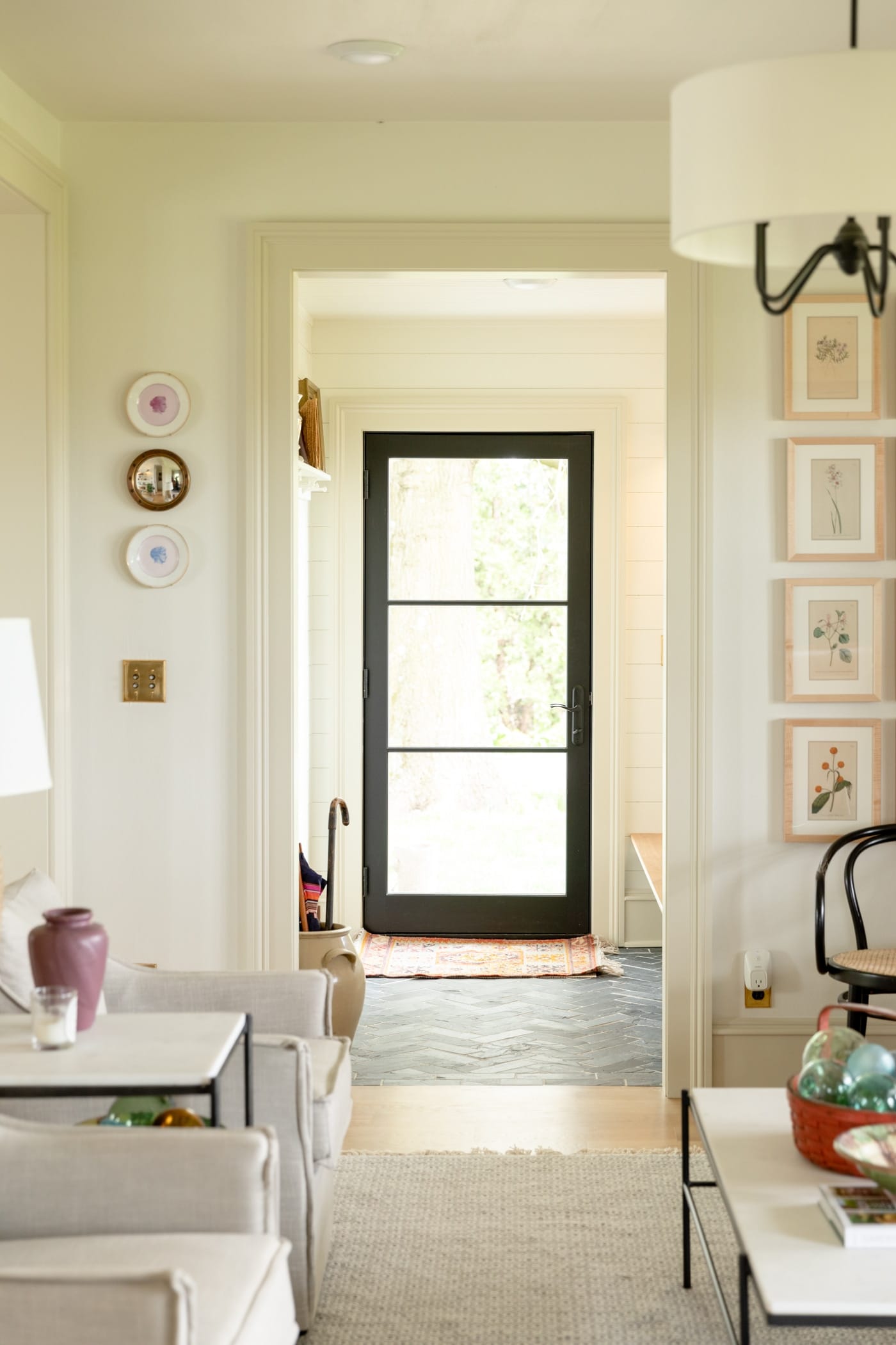 Black French door leading into entryway with black slate flooring and cream colored trim