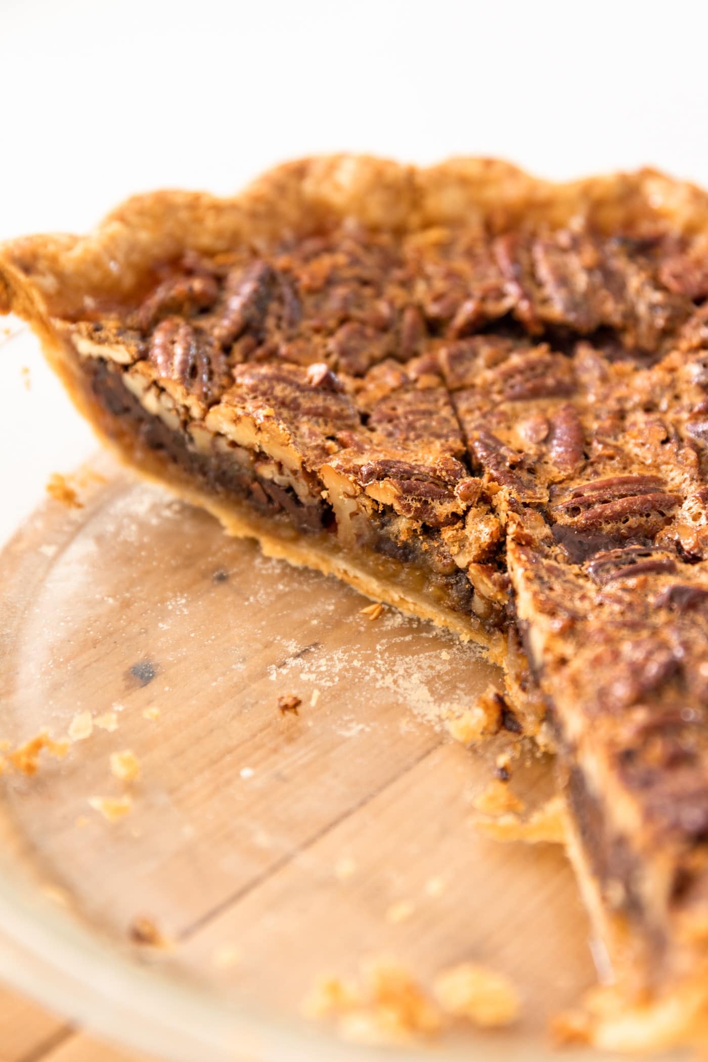 View of inside a pie dish with several pieces of pecan pie sliced out already with remaining pie still joined together