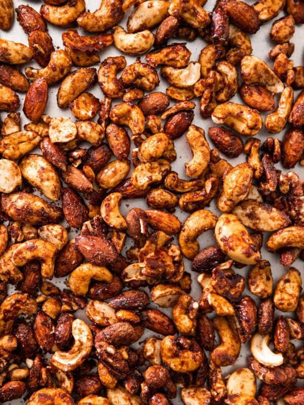 Top down view of spiced nuts sitting on silver baking dish after cooling from being in the oven