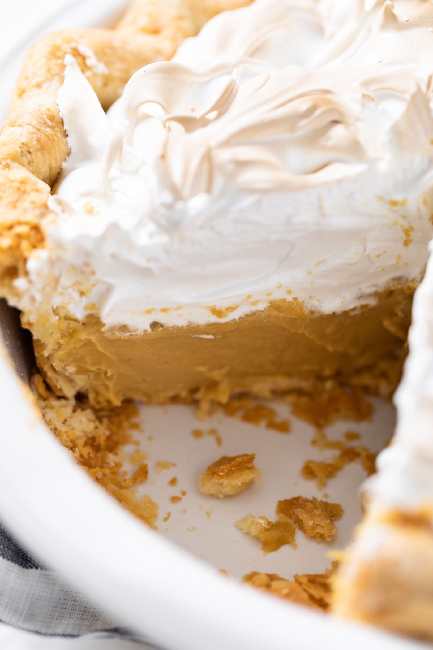 Side view of interior of butterscotch pie showing a slice cut out with pudding mixture on bottom and creme brûlée on top