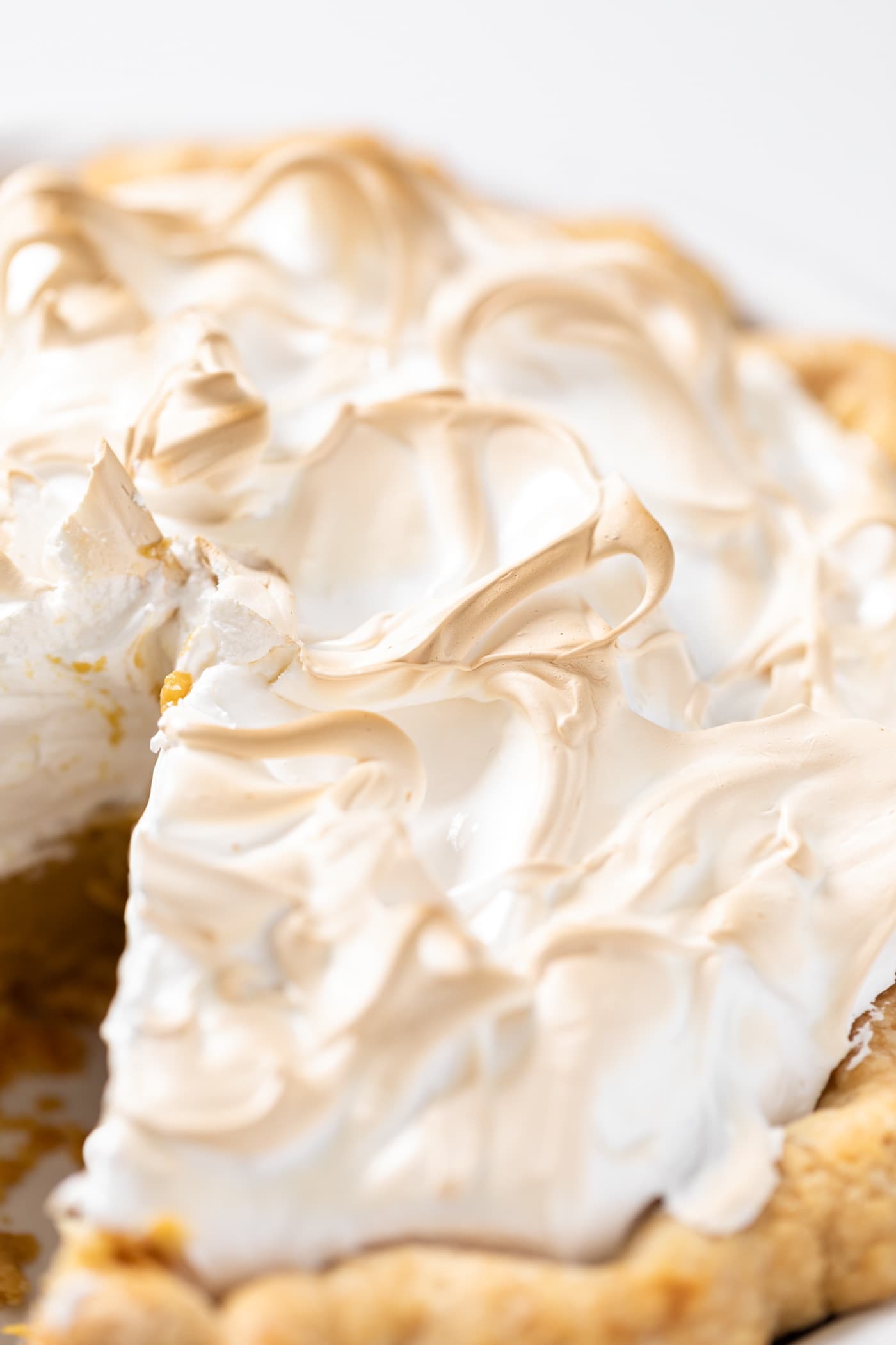 Swoops of creme brûlée on top of pie with part of golden crust peeking out