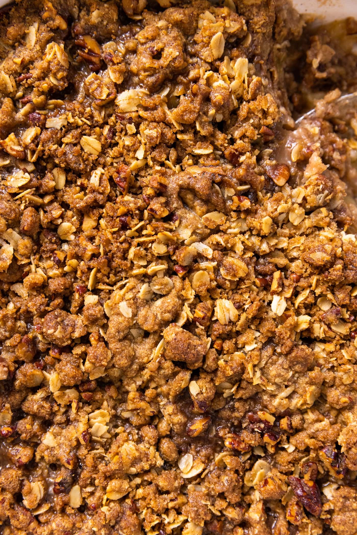 Top down view of streusel topping on top of apple crisp with golden brown color filling the entire picture