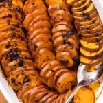 Top down view of white baking pan filled with slices of sweet potatoes covered with chipotle sauce and thyme