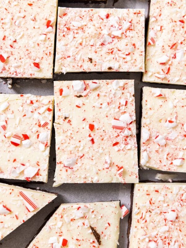 Top down view of peppermint bark sitting on metal tray with pieces cut into unequal amounts