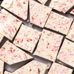 Top down view of pieces of peppermint bark sitting on metal container topped with pieces of peppermint candy