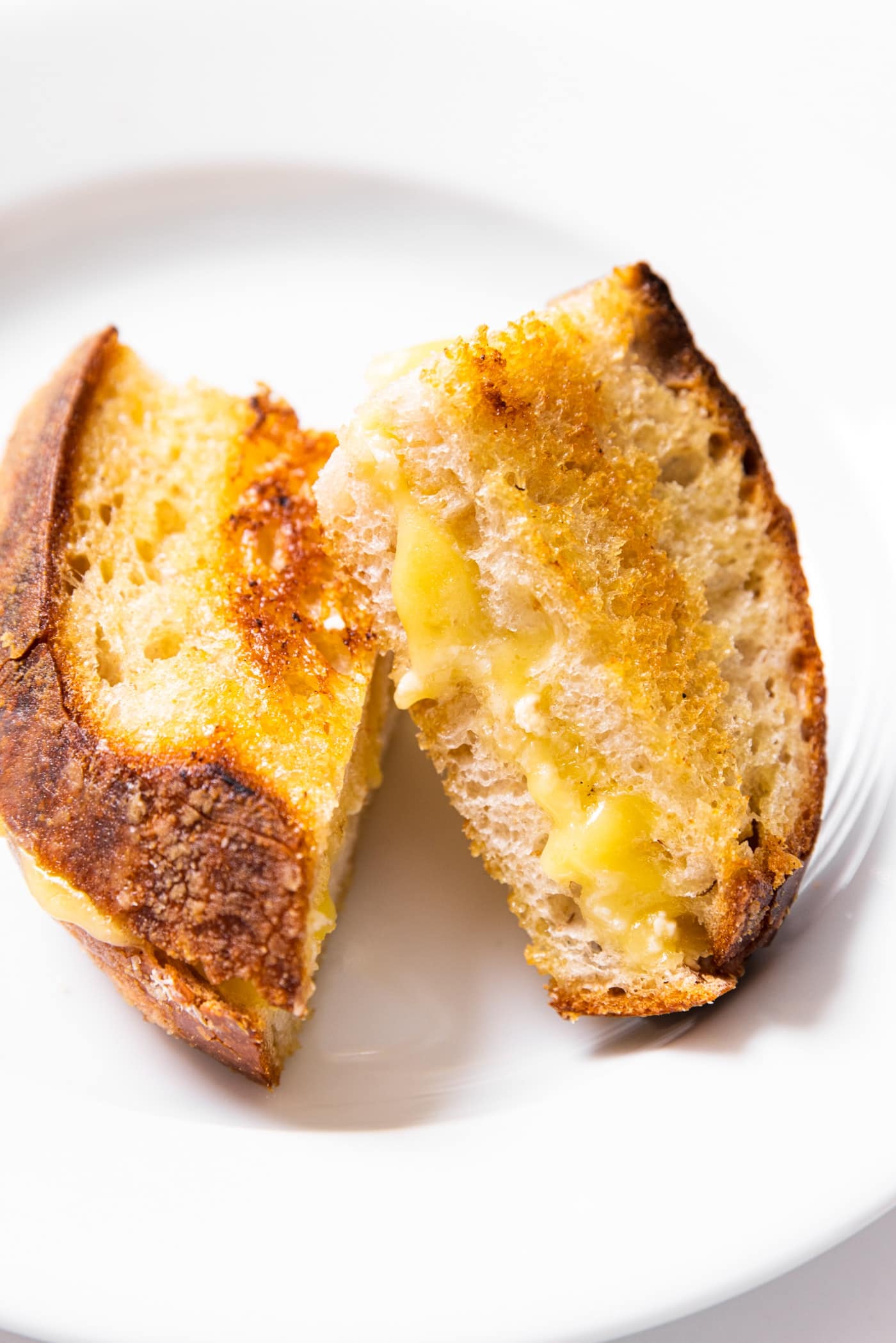 White plate with two slices of grilled cheese sitting on top