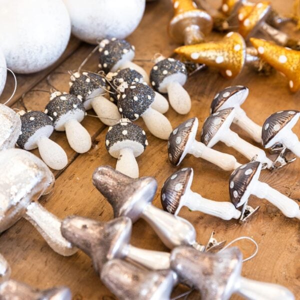 Lots of various silver and gold colored mushroom ornaments sitting on wooden table