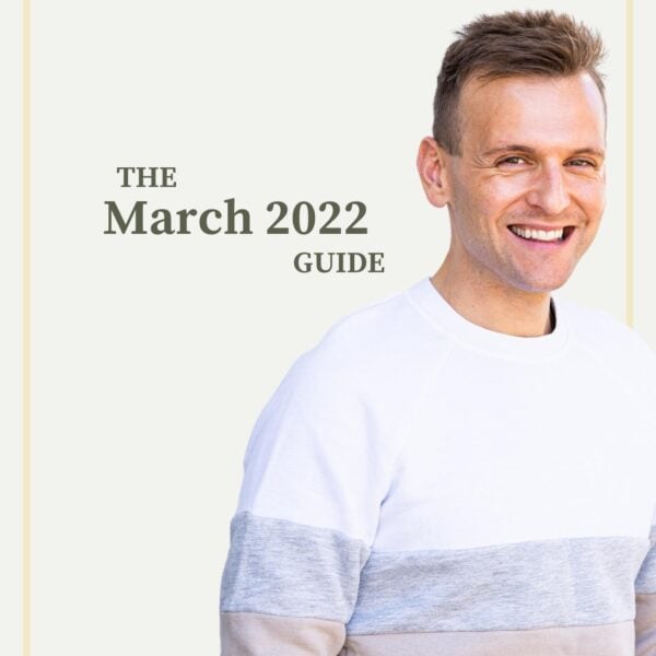 Kaleb Wyse standing in front of taupe background wearing white, gray, and tan sweater with words describing month and year on background.
