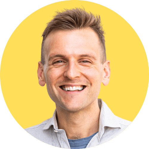 Kaleb Wyse wearing white collared shirt standing in front of bright yellow background.