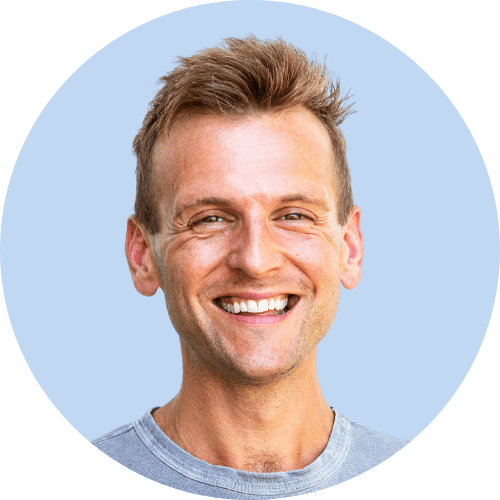 Circular picture with tanned Kaleb Wyse wearing light blue shirt in front of light blue background.