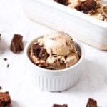 Small white bowl filled with espresso brownie ice cream with rest of ice cream sitting in loaf pan in background.