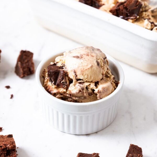 Small white bowl filled with espresso brownie ice cream with rest of ice cream sitting in loaf pan in background.