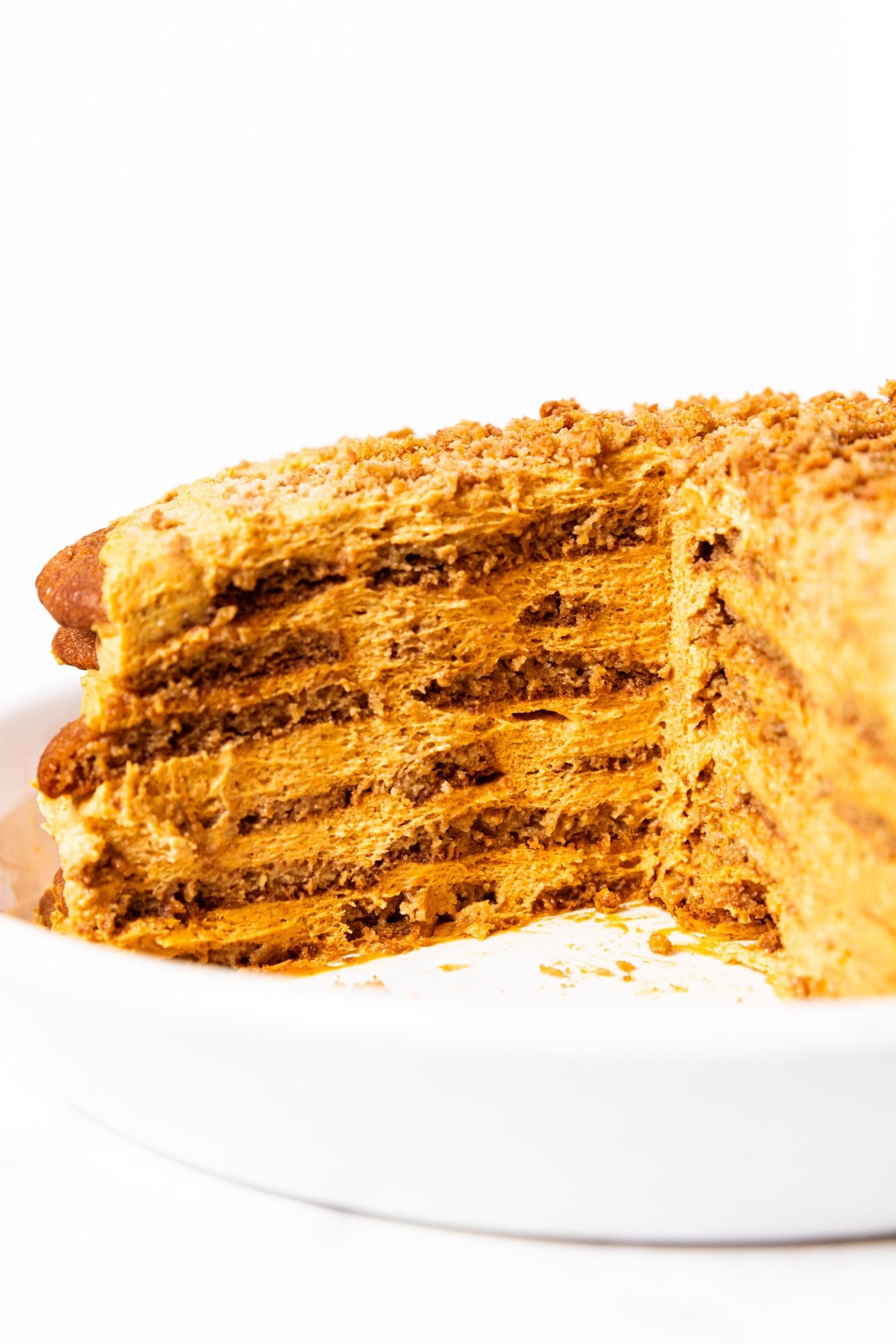 Interior of pumpkin icebox cake showing all of the different layers including pumpkin whipped cream and gingersnap cookies.