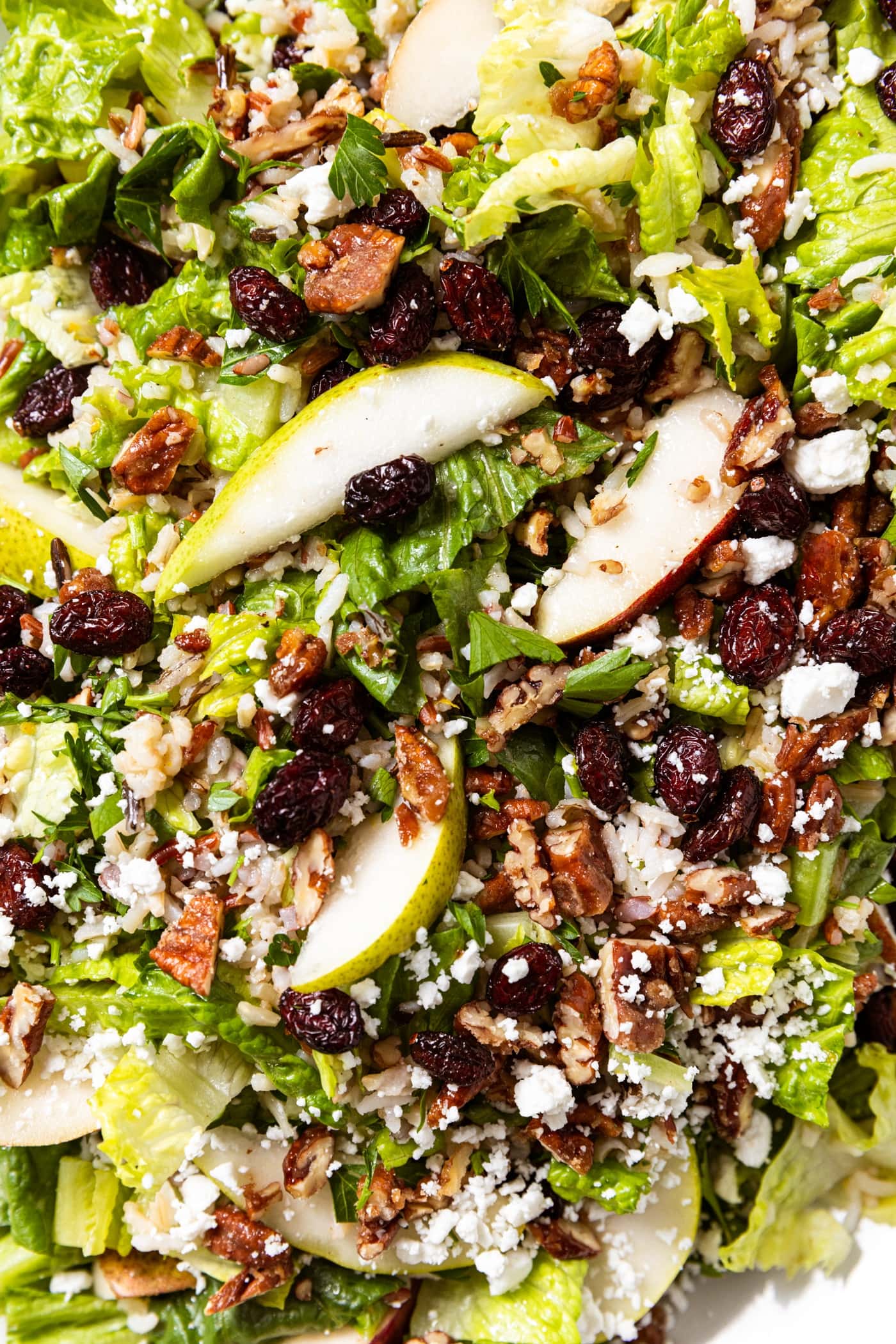 Wild rice and pear salad topped with dried cranberries and feta cheese with chopped praline pecans all over the top.