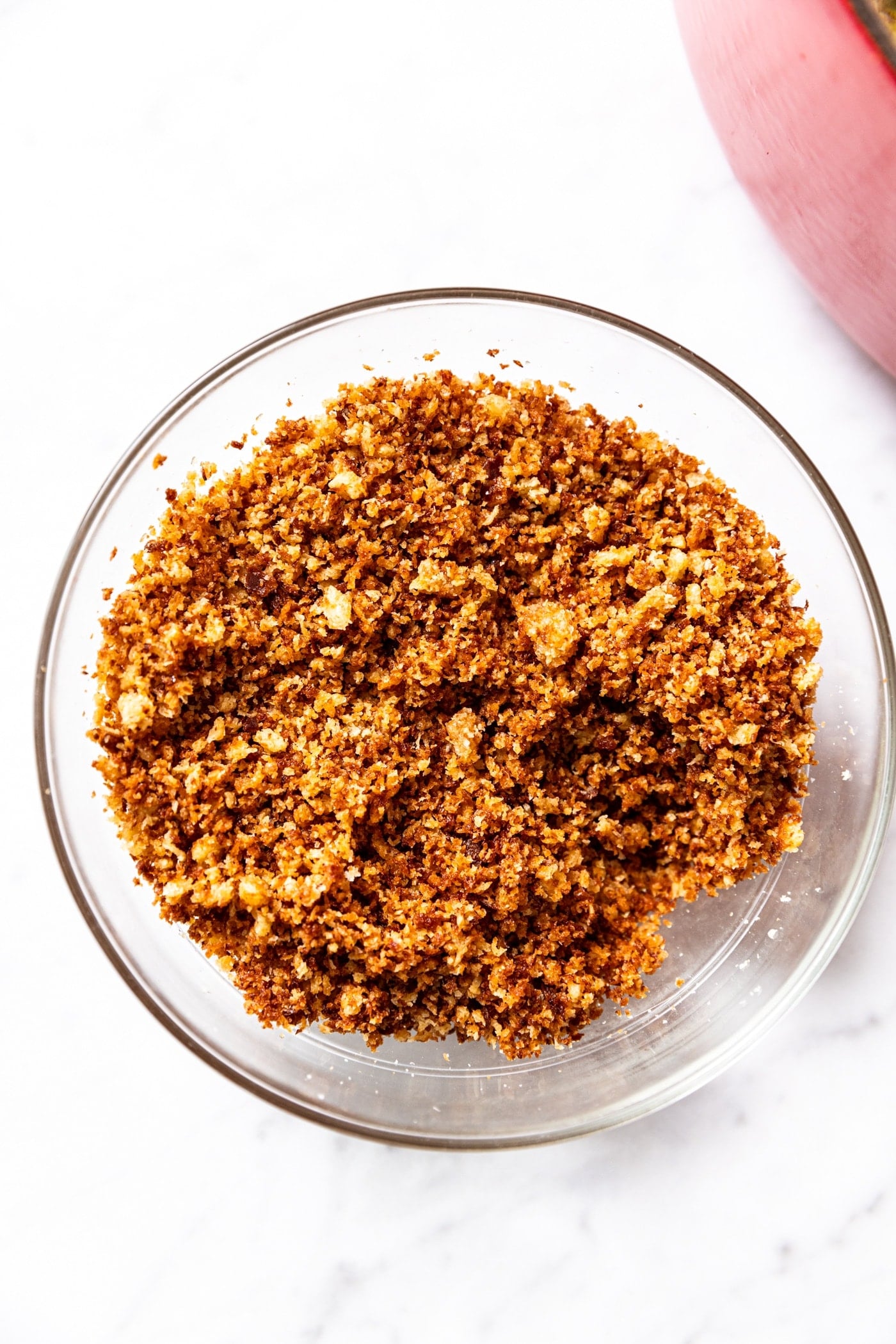 Glass bowl filled with browned bread crumbs with toasted tops.