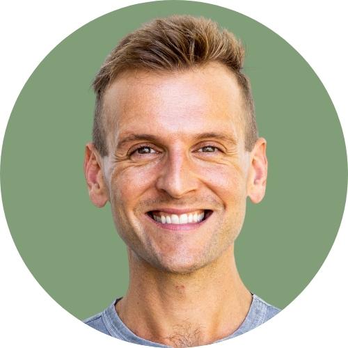 Kaleb Wyse headshot standing in front of light green background.