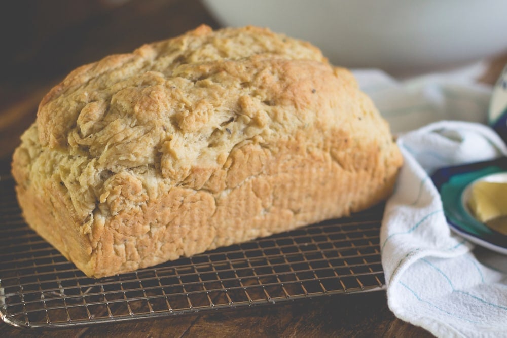 A loaf of bread sits on a metal rack.