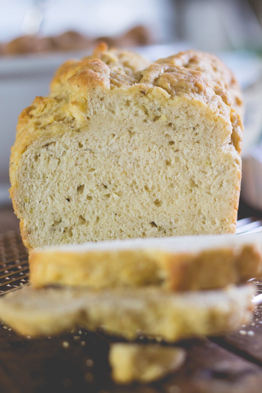 A slice of bread sits in front of the loaf it was cut from.