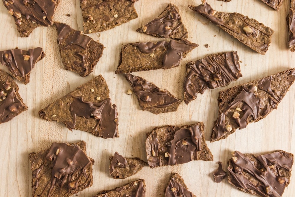 Irregular pieces of brownie thin scatter across a table.