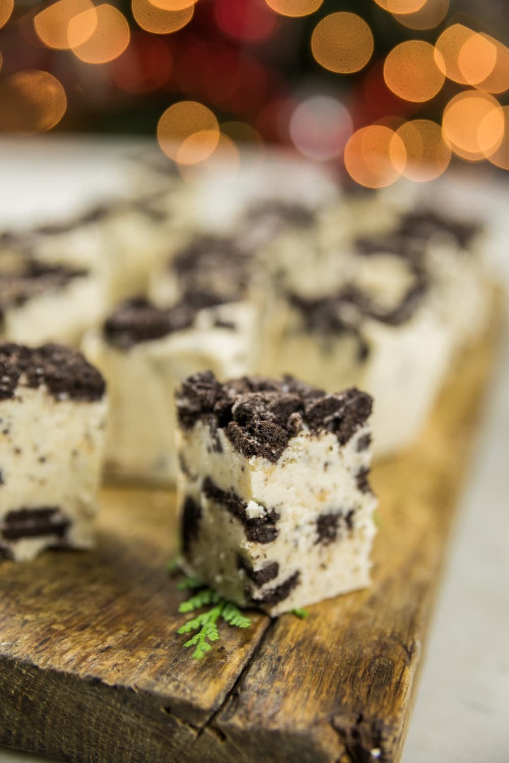 A piece of fudge with crushed Oreo sits on a wooden block.