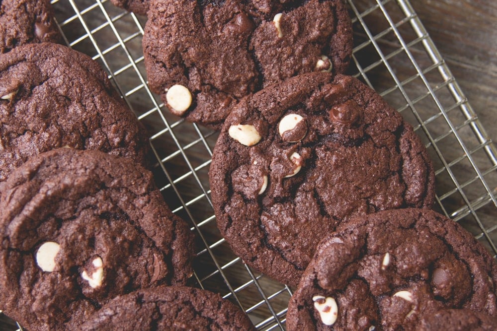 Rows of fudge cookies lie on a cooling rack.