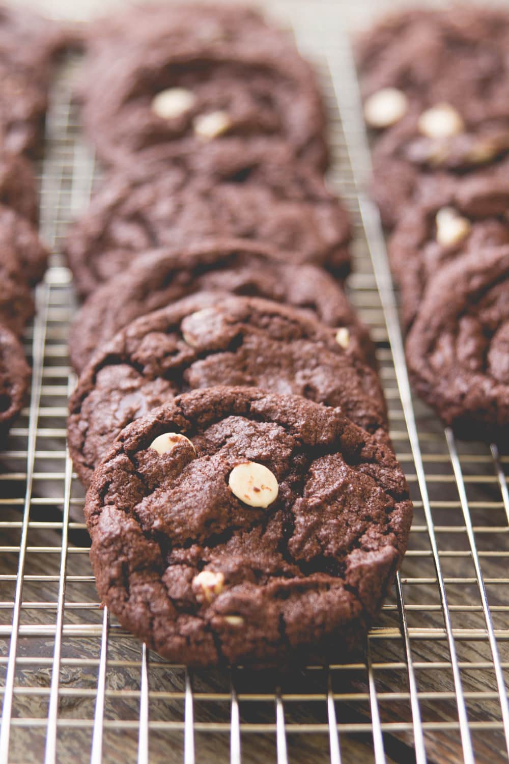 Chocolate cookies lie overlapped on a cooling rack.