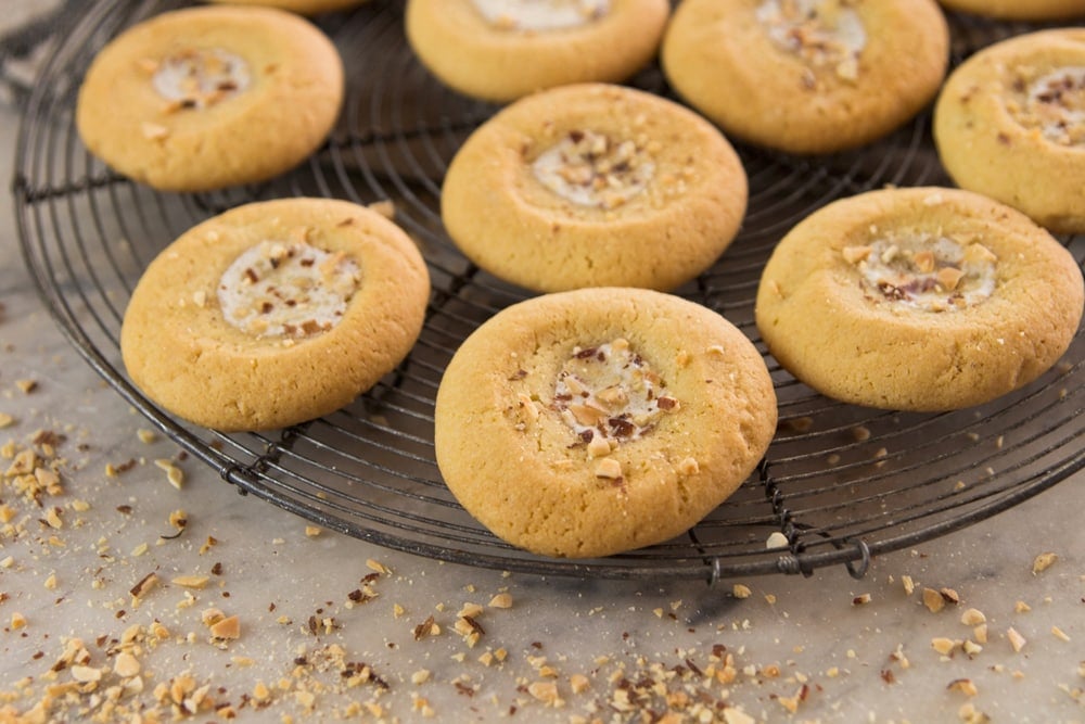 Cookies topped with honey butter sit on a cooling rack.